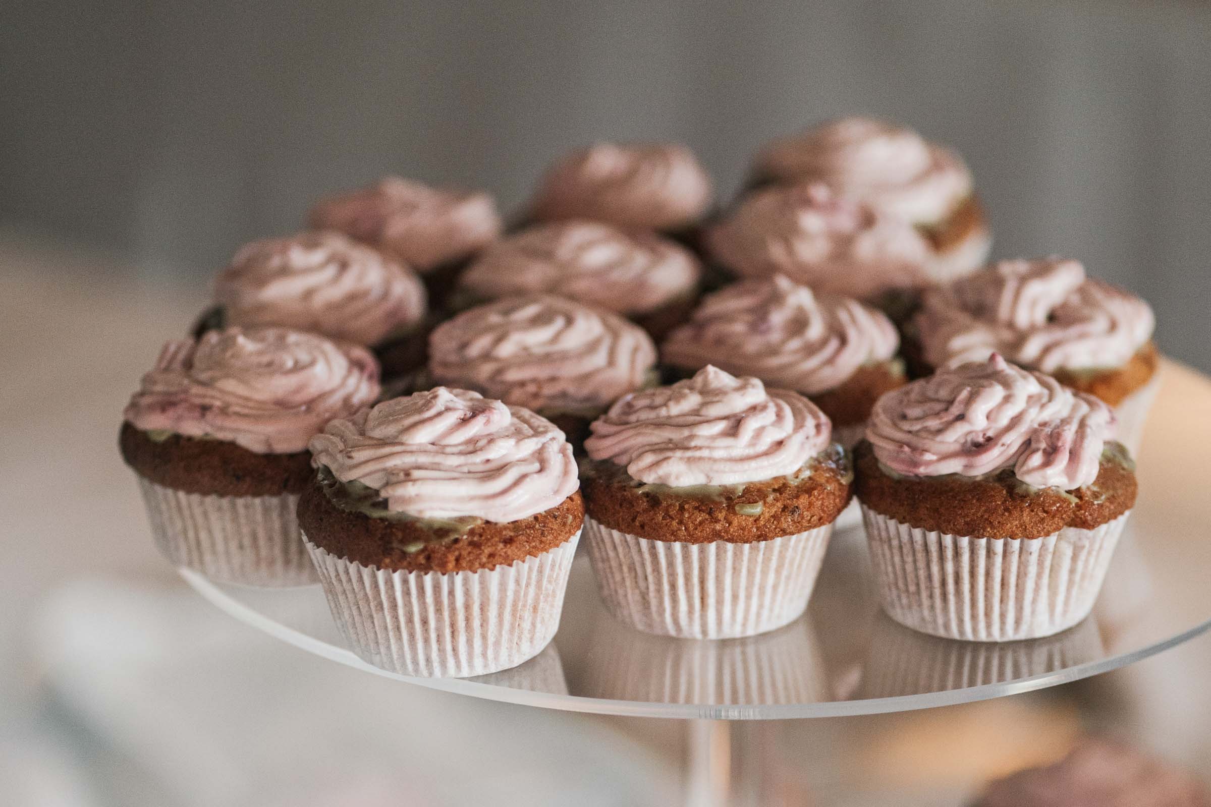 Cupcakes mit rosa Topping auf dem Sweet Table der Hochzeit.