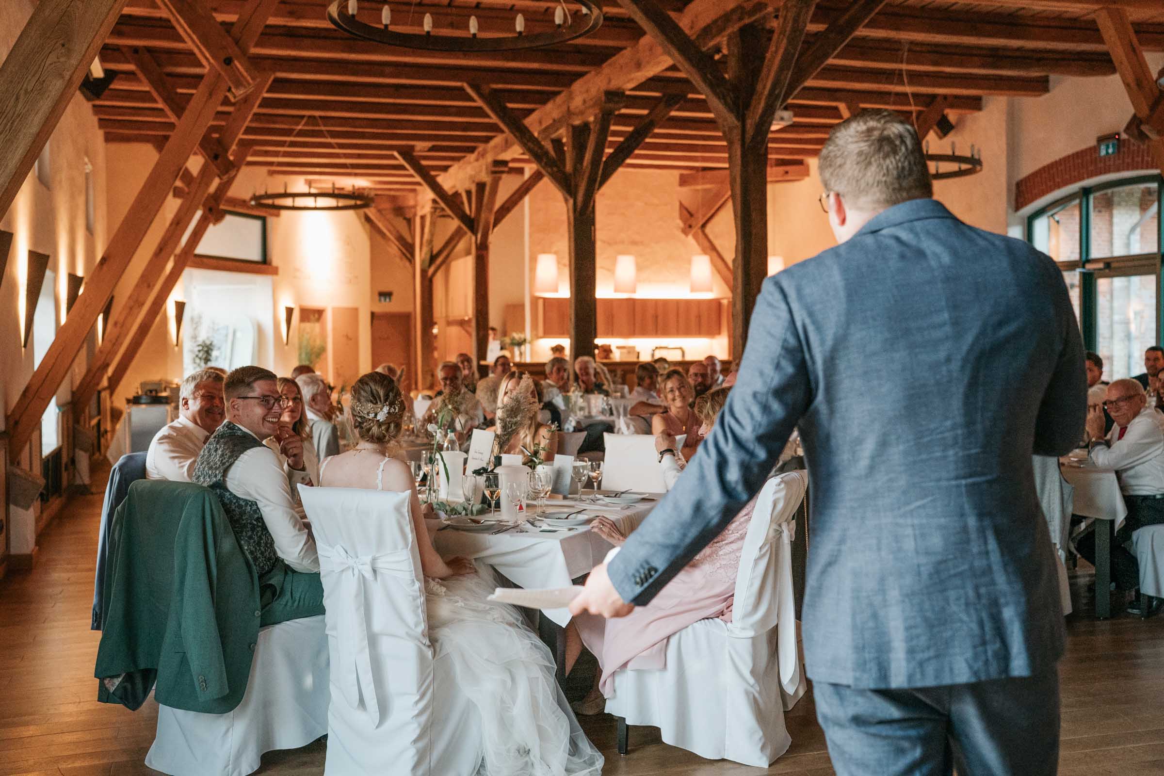 Gast hält eine Rede vor der Hochzeitsgesellschaft im Saal.