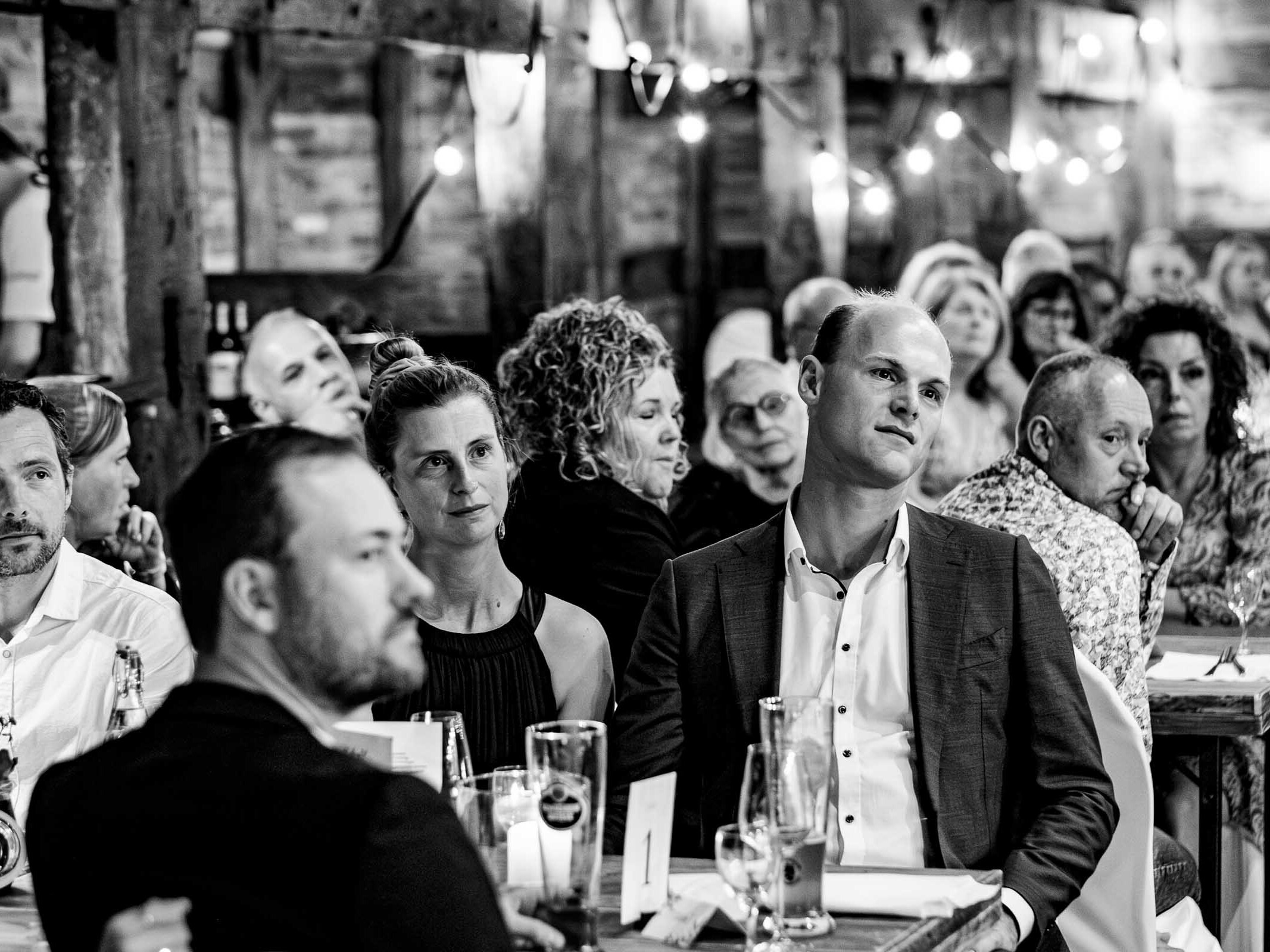 meyers | hof | hannover | gaeste | beim | essen | dinner | reportage | familystyle | sharing | platters | lachende | gaeste | toast | weinservice | kerzenlicht | holztische | entspannte | atmosphaere | candid | food | momente