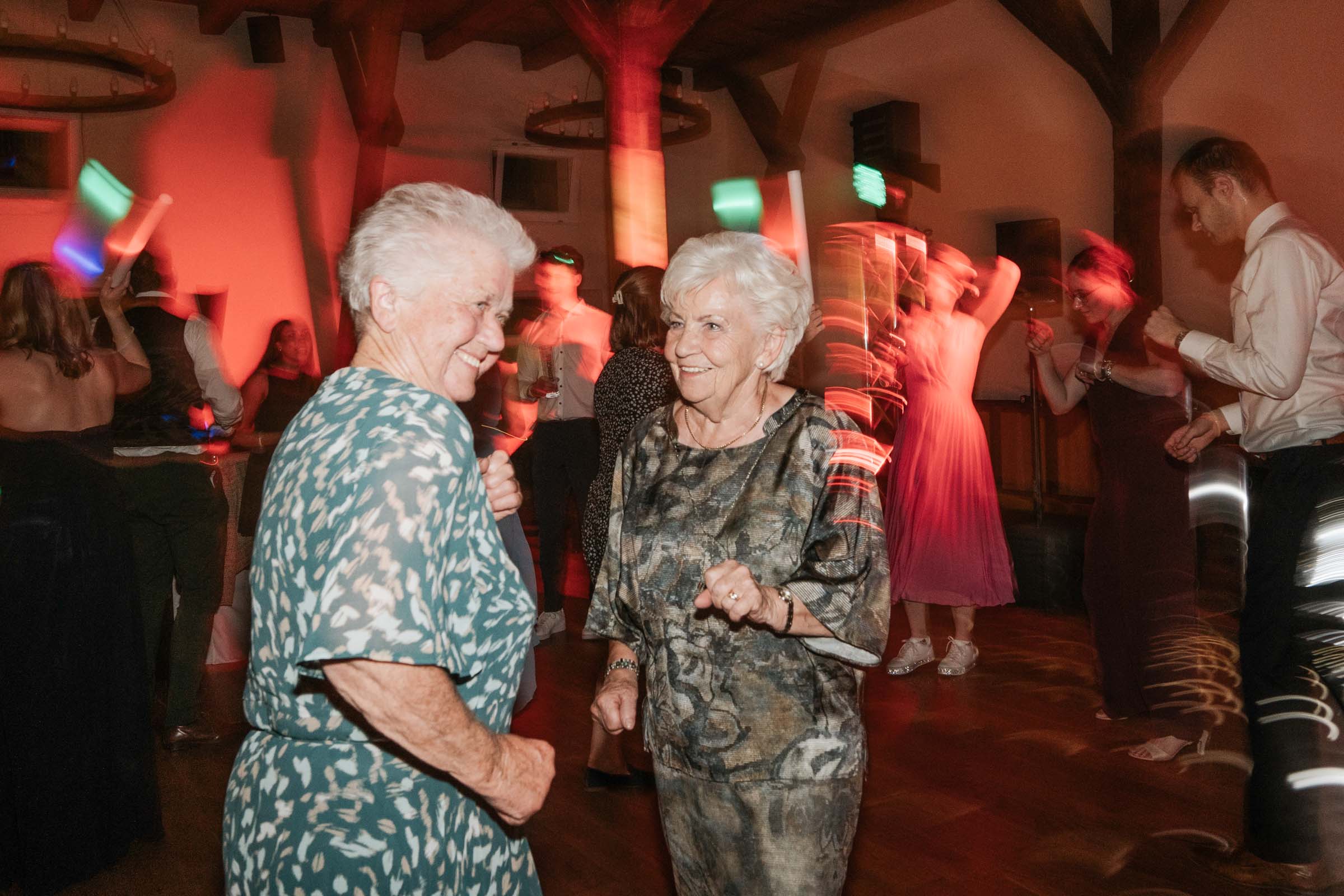 Zwei ältere Gäste tanzen lachend auf der Hochzeitsparty.