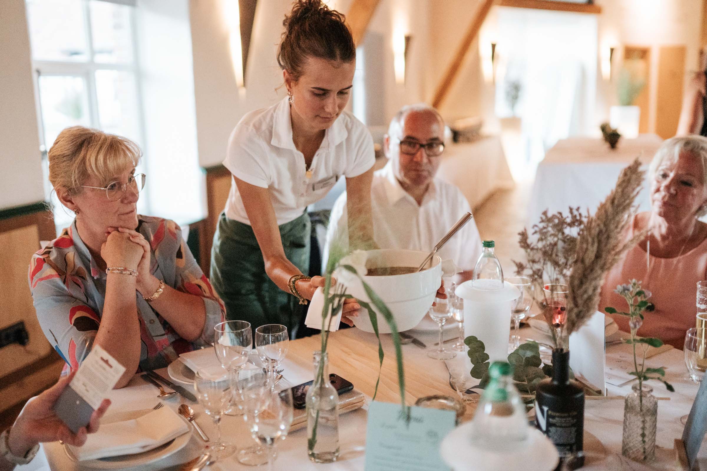 Servicekraft serviert Suppe während des Hochzeitsdinners.