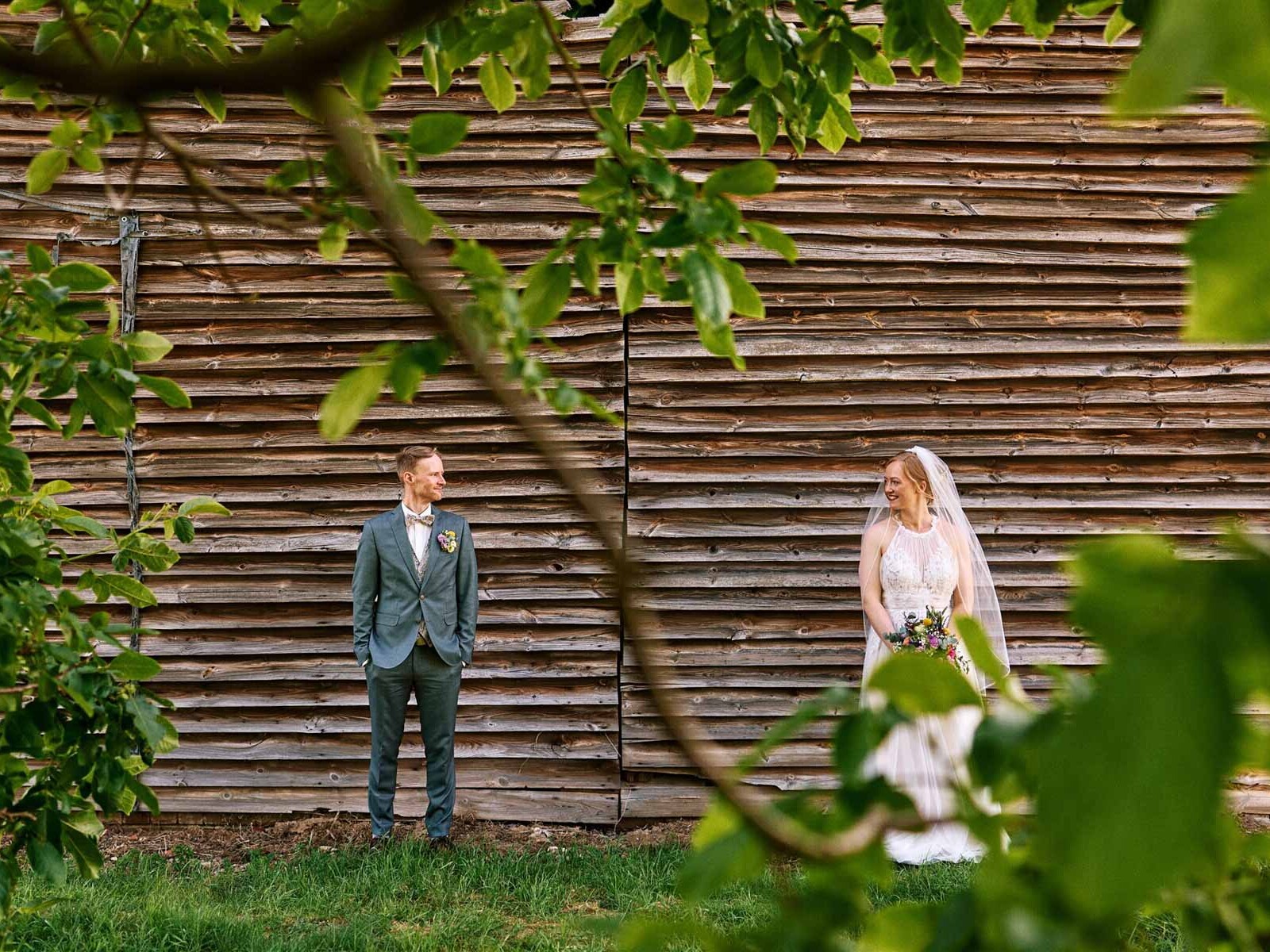 Braut und Bräutigam vor Holzscheune im Hofcafé Nettelrede, Hochzeit nahe Bad Münder mit DJ Lehmann-Eventservice.
