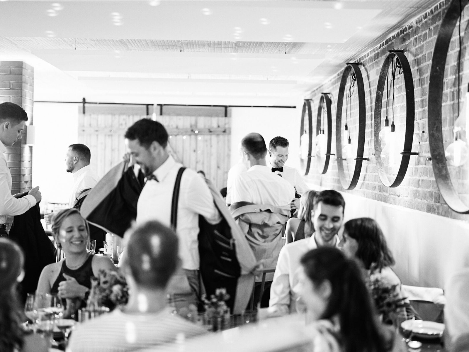 Schwarz-Weiß-Aufnahme fröhlicher Hochzeitsgäste im Hofcafé Nettelrede, Musik von DJ Lehmann-Eventservice.