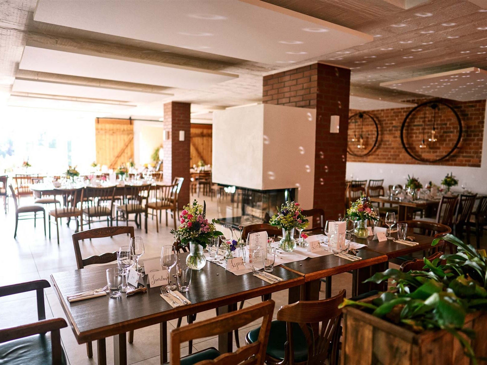 Gedeckte Hochzeitstische mit Blumen im Hofcafé Nettelrede bei Bad Münder, vorbereitet für die Party mit DJ Lehmann-Eventservice aus Hannover.