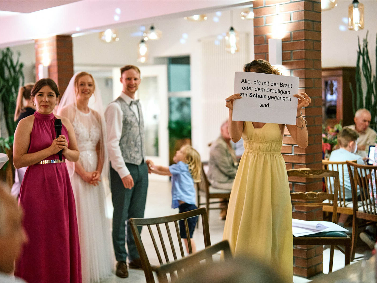 Gäste moderieren ein Hochzeitsspiel im Hofcafé Nettelrede, Brautpaar im Hintergrund, DJ Hannover Bad Münder.