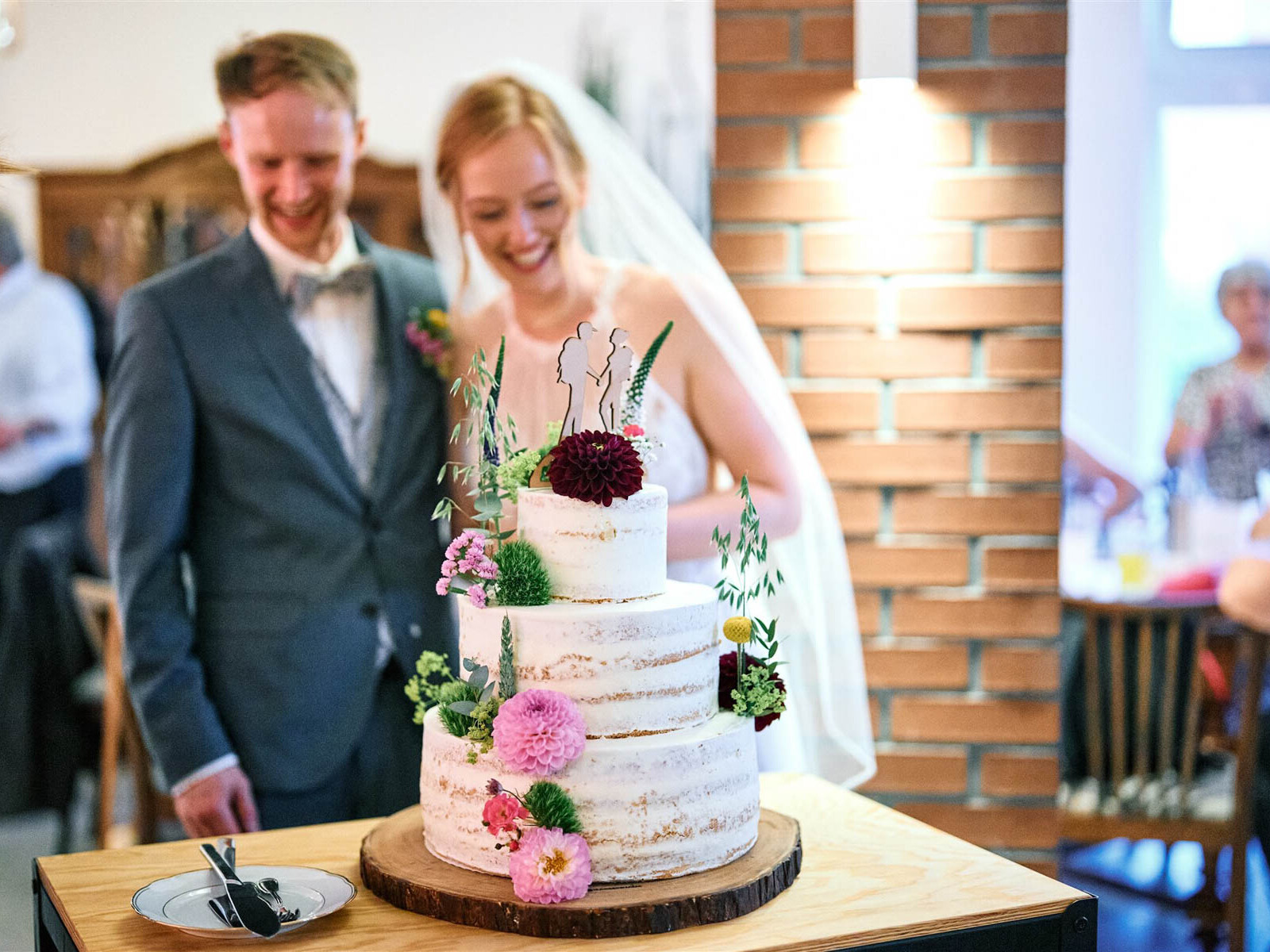 Hochzeitstorte mit Blumen im Hofcafé Nettelrede vor Braut und Bräutigam, Feier mit DJ aus Hannover.